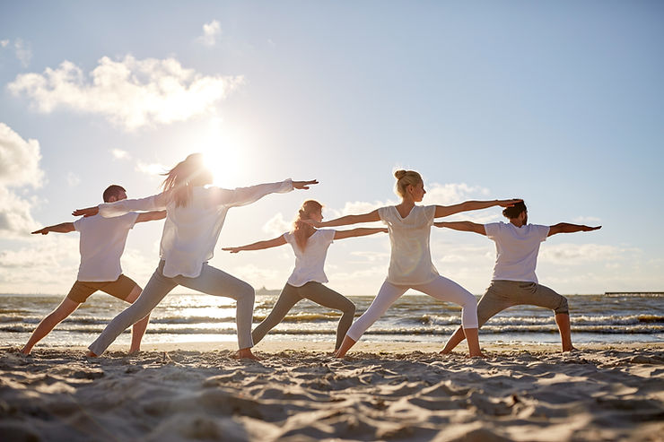 a group of people standing on top of a sandy beach.