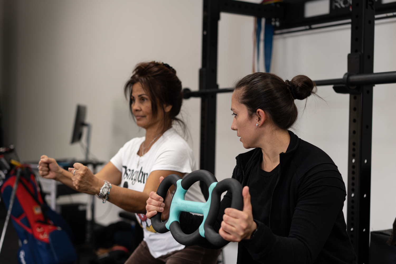 a woman holding a pair of scissors in a gym.
