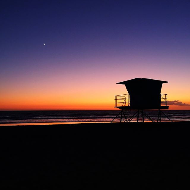a lifeguard tower sitting on top of a beach next to the ocean.