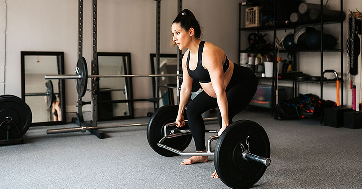 a woman squatting on a barbell in a gym.