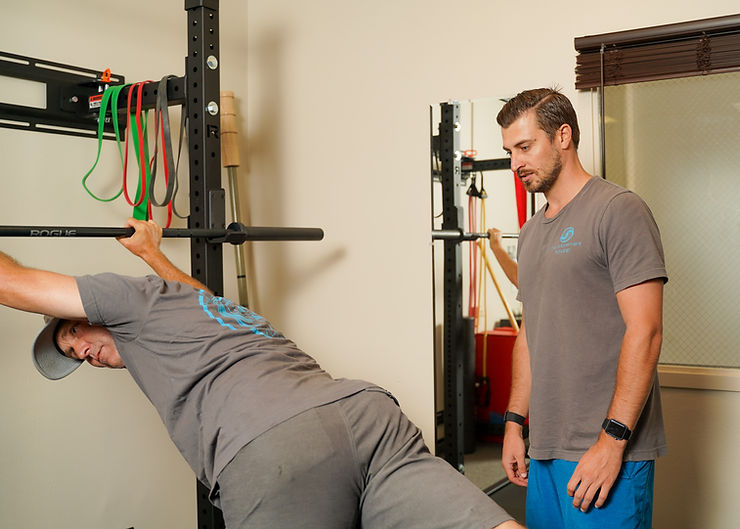 a man doing a back stretch on a pull up bar.