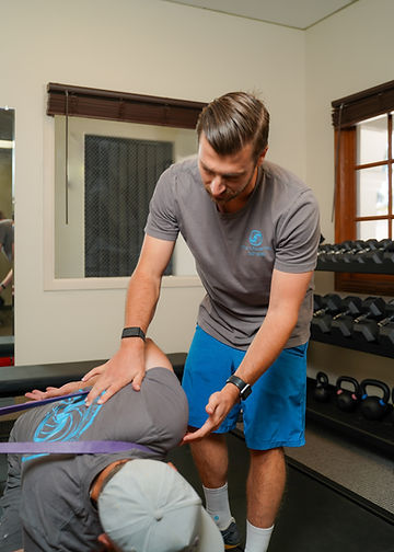 a man is doing exercises with another man in a gym.