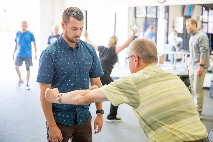 a man in a blue shirt and a man in a green shirt.