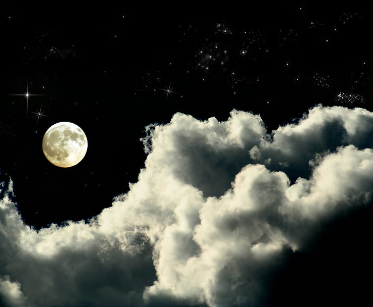 a full moon in the night sky with clouds.