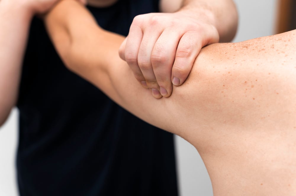 Hands applying pressure on arm